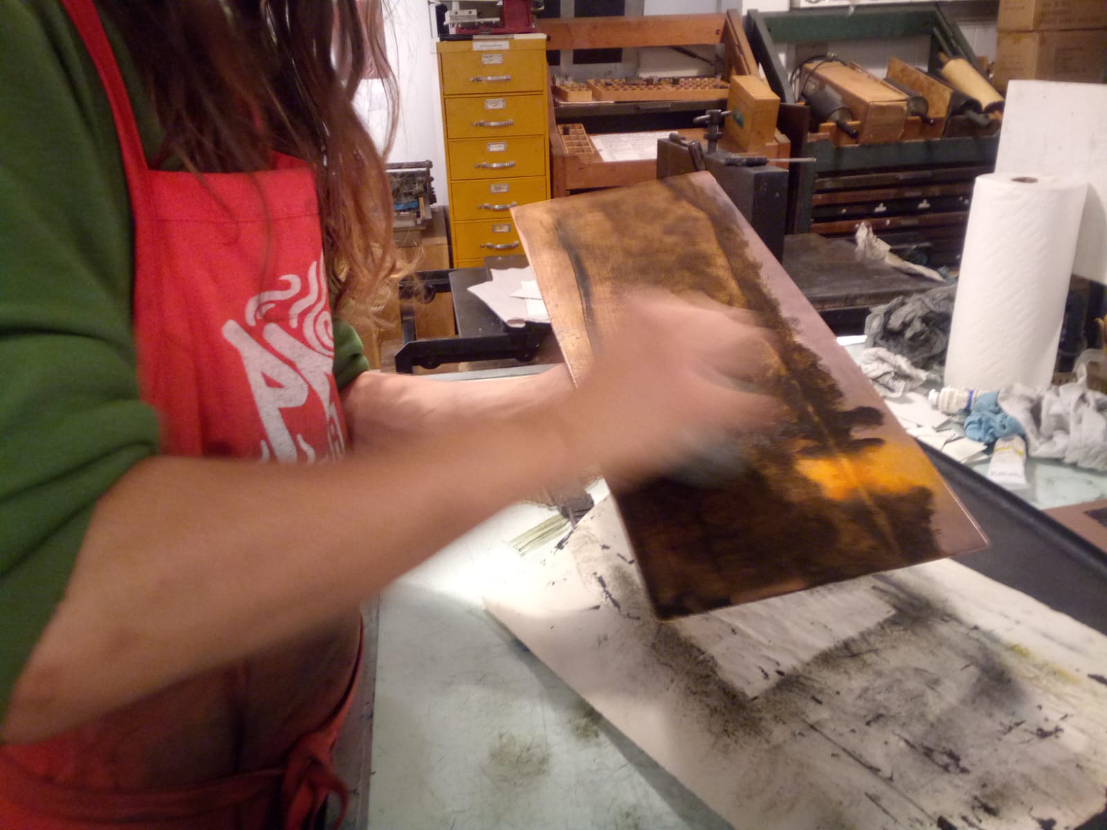 An image of an etching plate being wiped.